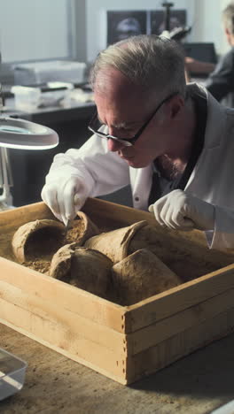 archaeologist excavating and analyzing ancient pottery fragments