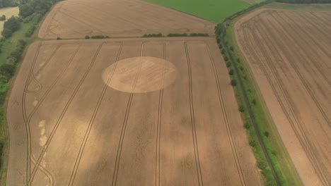 aerial view of tufton cultivated golden crop circle on hampshire ploughed wheat field countryside