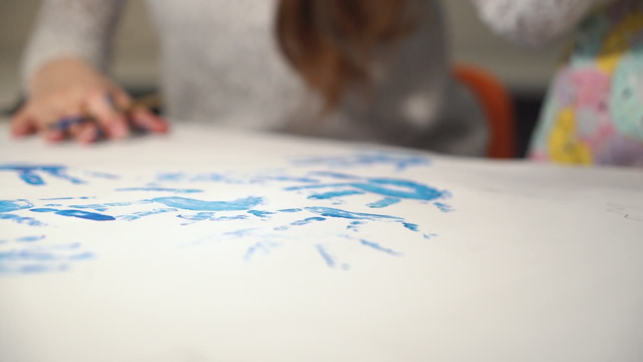Imprint of children's hands made with paint. Child making hand prints on paper