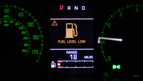 low fuel level warning light on car dashboard display