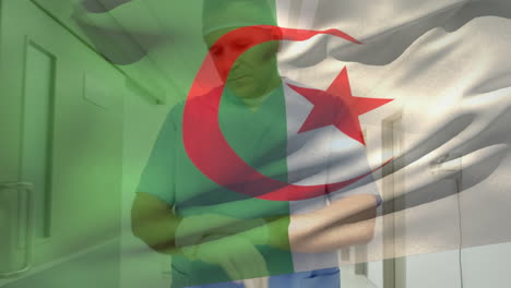 algeria flag waving against caucasian senior male health worker wearing surgical gloves at hospital