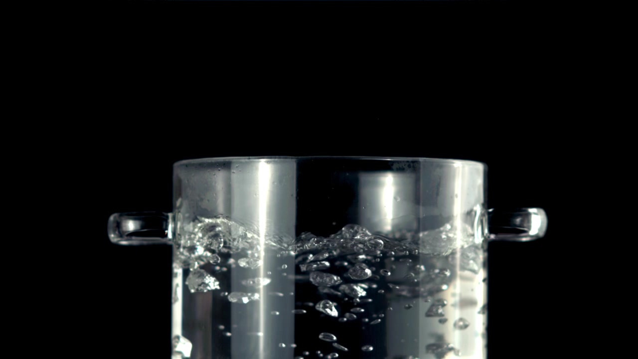 Primo piano di acqua in ebollizione in una pentola di vetro trasparente