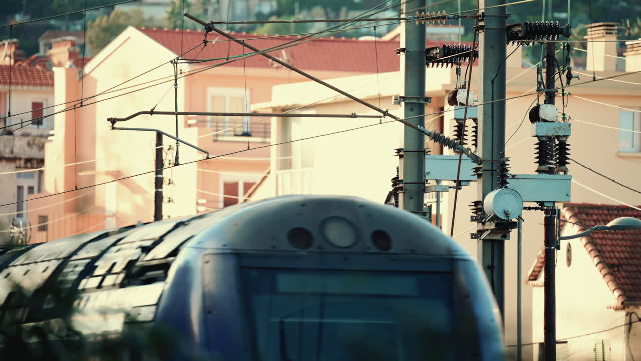 Primer plano de un tren eléctrico que pasa por debajo de las líneas eléctricas aéreas y las estructuras de servicios públicos