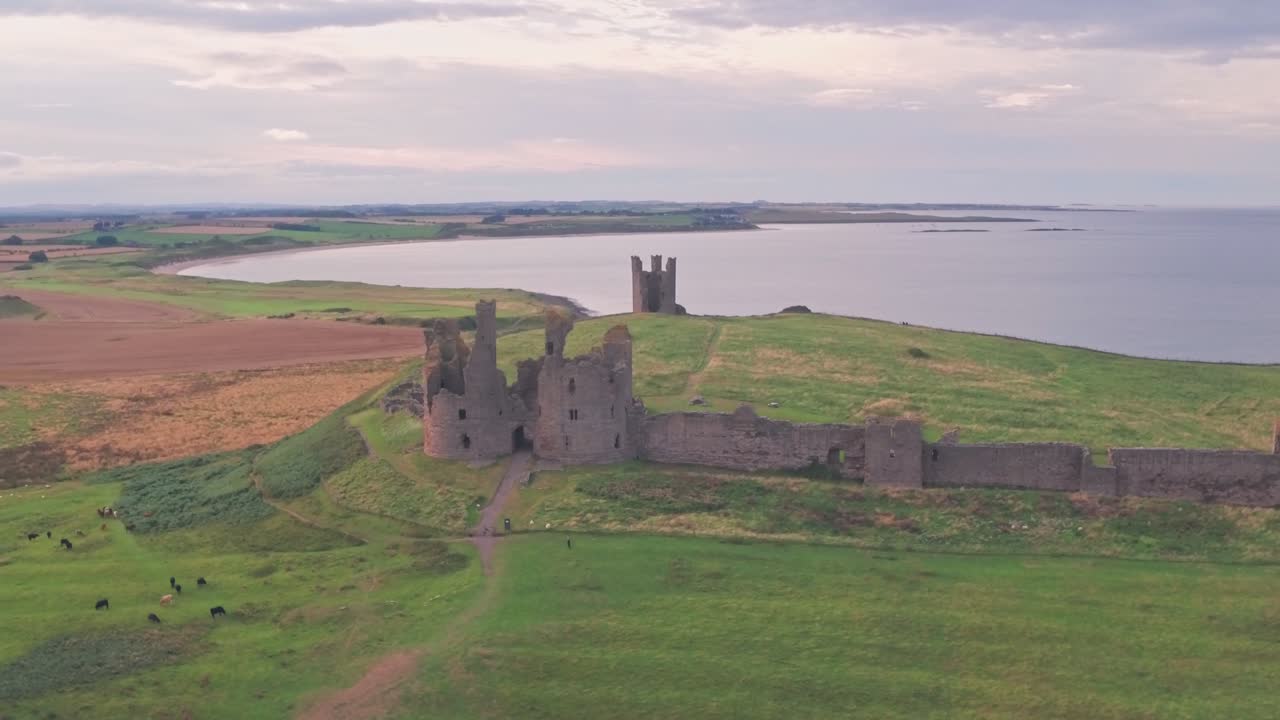 Dunstanburgh Castle ved solnedgang i Northumberland, England, Storbritannien. Droneoptagelse
