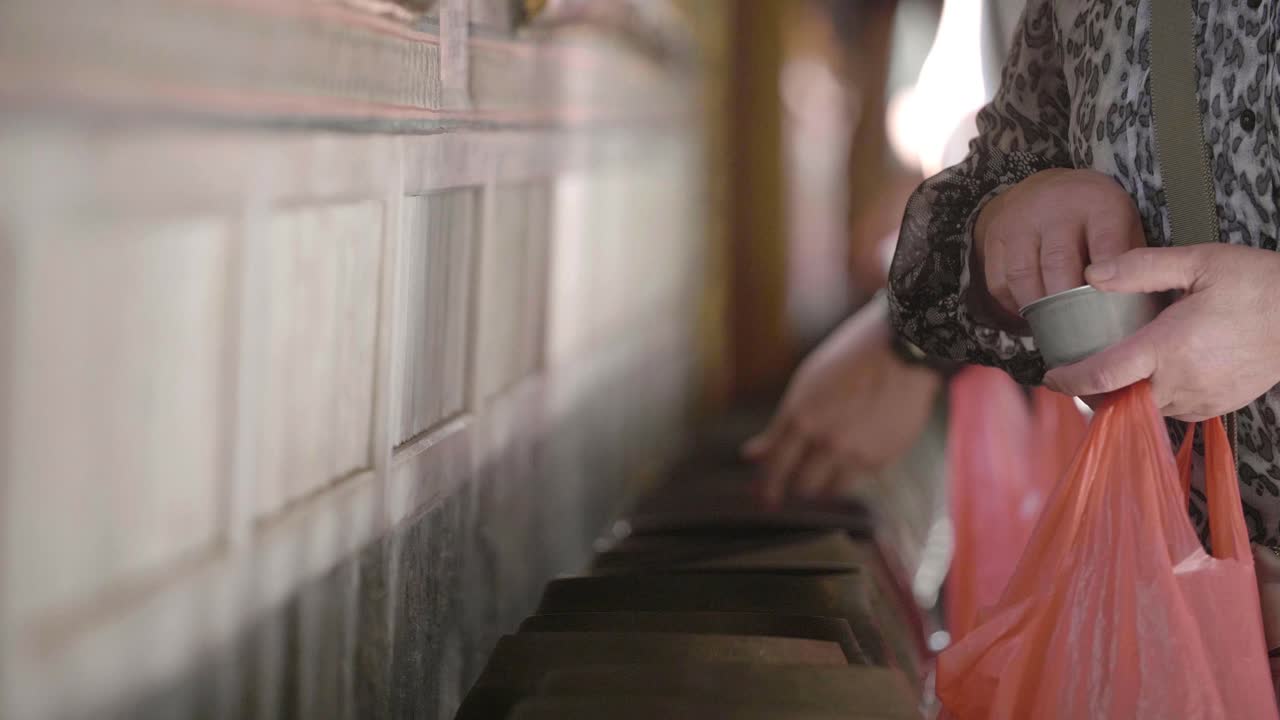 Hands Donating Alms in Buddhist Temple