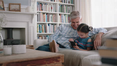 happy-grandfather-showing-little-girl-how-to-use-smartphone-teaching-curious-granddaughter-modern-technology-intelligent-child-learning-mobile-phone-sitting-with-grandpa-on-sofa