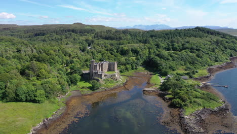 Castillo-De-Dunvegan,-Capturado-Por-Un-Dron-En-Una-Toma-Suave-Y-Panorámica-Alrededor-Del-Castillo,-Que-Muestra-El-Impresionante-Paisaje-Que-Rodea-El-Castillo,-Así-Como-Los-Magníficos-Terrenos