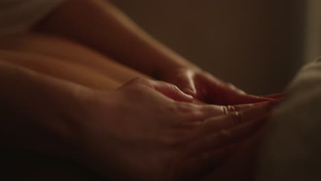 professional back massage hands in dimly lit room