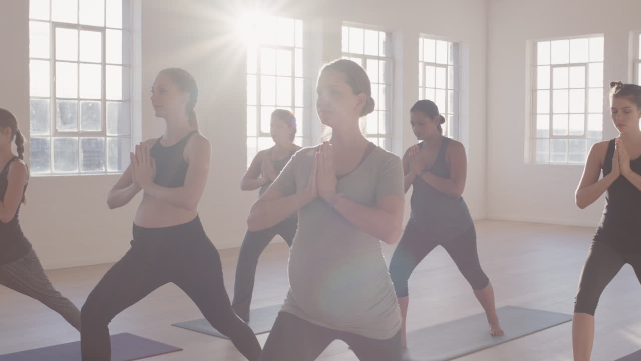 clase de yoga de mujeres jóvenes embarazadas practicando pose de oración disfrutando de un estilo de vida saludable entrenamiento físico en grupo en un estudio de ejercicios al amanecer