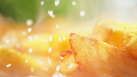 salado de papas fritas - cuñas de patata crujientes salpicadas con sal gruesa en macro y cámara lenta