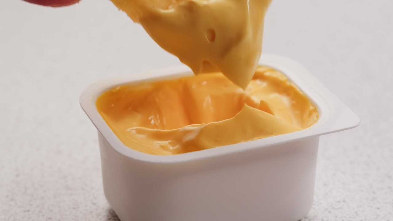 Dipping French Fries in Cheese Sauce