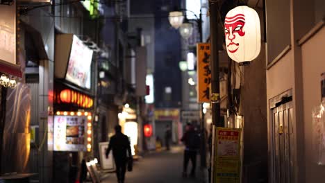 pedestrians walking through a lit city alleyway