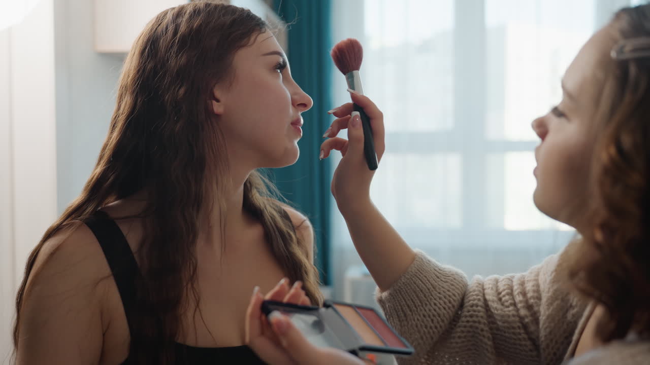 Model Applies Makeup, Artist Uses Fluffy Brush For Contouring, High Key Lighting Highlights Makeup Details Beautifully, Focused Application Creates Editorial Glow And Emphasizes Skin Contours