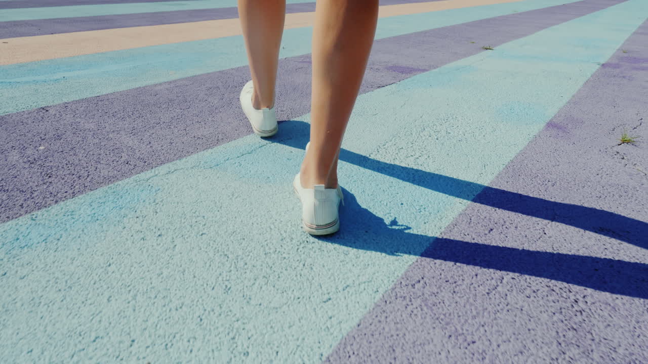 Follow Shot Of Walking Feet In Sports Shoes Walking On Colorful Motley Asphalt
