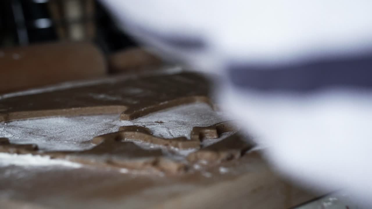 femmina caucasica che taglia l'albero di natale dalla pasta di pan di zenzero