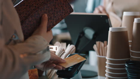 happy barista woman serving customer using credit card making contactless payment buying coffee spending money in cafe