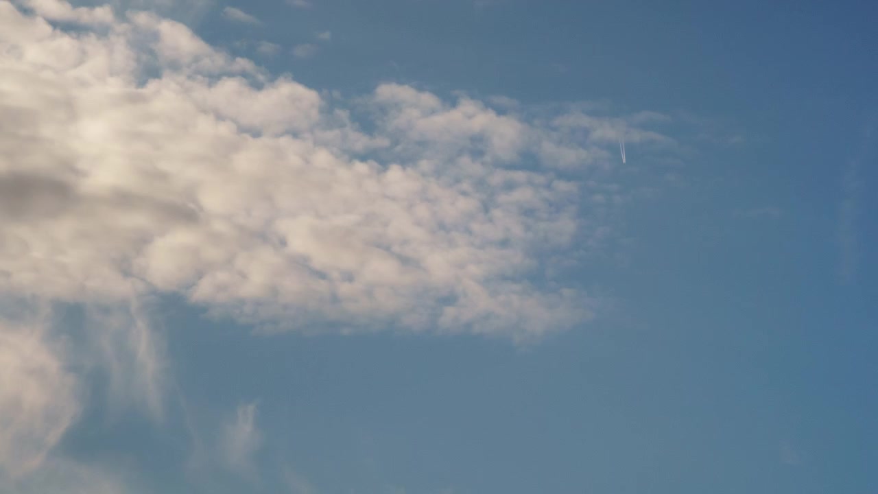 Cinematic timelapse capturing soft Altocumulus clouds drifting over a bright blue sky. Perfect for peaceful backgrounds, nature documentaries, and dreamy transitions.
