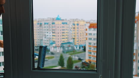 window cleaner working with wet glass window. close up view of cleaning window.