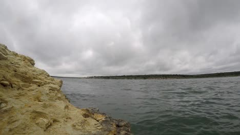 time lapse rocks by large lake from rock shoreline