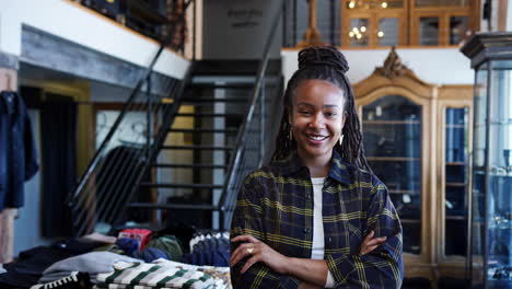 Portrait-Of-Smiling-Female-Owner-Of-Fashion-Store-Standing-In-Front-Of-Clothing-Display