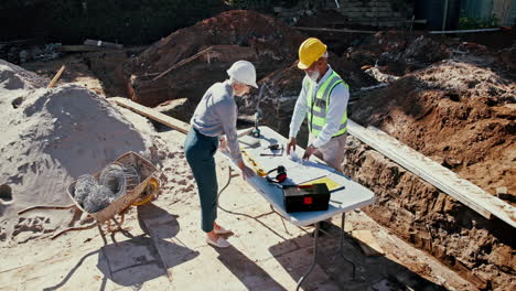 construction workers reviewing plans on building site