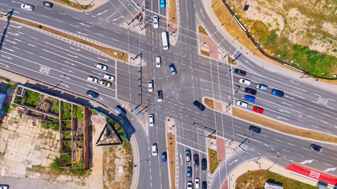 Overhead view of vehicles at an urban junction, Bratislava, Slovakia. Straight down aerial shot of cars crossing white markings on asphalt roads.