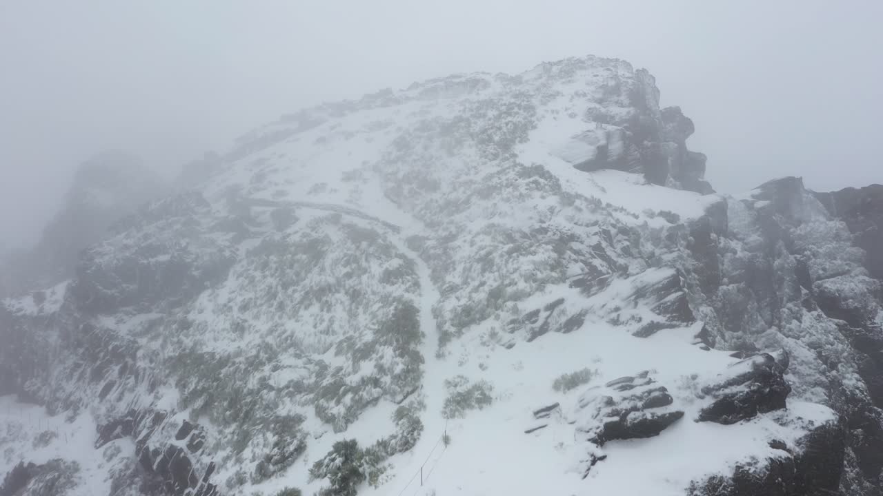 Aerial shot of Ninho da Manta in Madeira, flying forwards in the mysterious and dark snowstorm