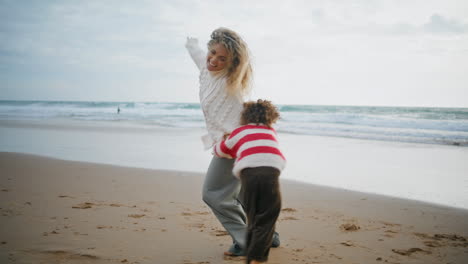 family playing airplane pilot on autumn ocean shore. joyful mother son running