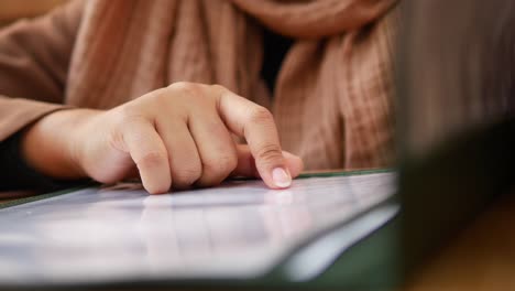 woman's hand pointing at a menu in a restaurant