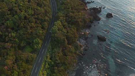 Yakushima-coastline-road-and-Cove,-Aerial-view-at-sunset-in-Japan