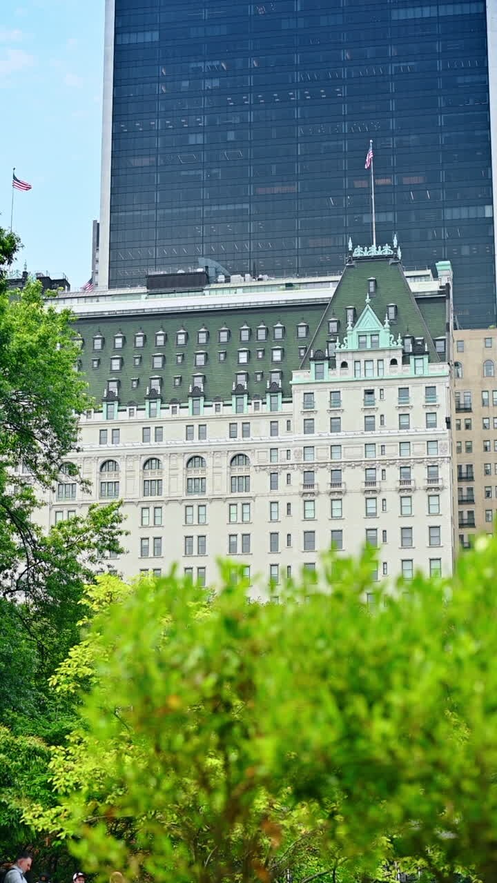 Central Park ed edifici vicini. Central Park a Manhattan mostra una vegetazione lussureggiante accanto all'architettura storica in una giornata di sole