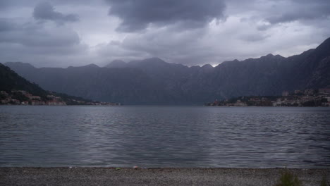 Dramatic-storm-clouds-over-a-distant,-dark,-lonely-island