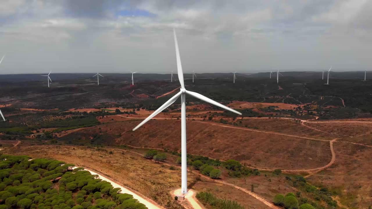 Aerial dolly shot approaching a wind farm in Barao de Sao Joao, Portugal.