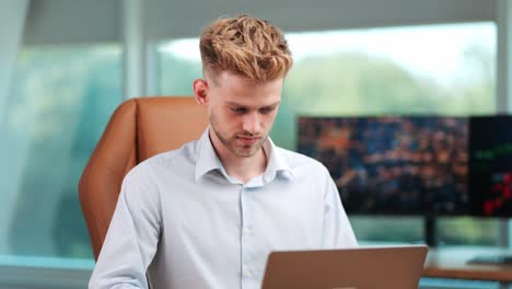 young businessman engaged with notebook in modern office with trading screens