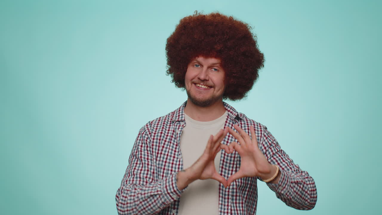 el hombre sonriente hace un gesto de corazón demuestra un signo de amor expresa buenos sentimientos y simpatía
