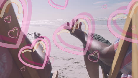 animación de corazones sobre una pareja de ancianos afroamericanos acostados en tumbonas en una playa soleada