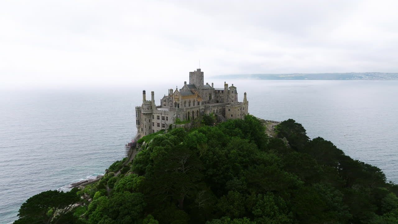 Chiesa normanna e castello medievale con alberi fitti in Cornovaglia, Inghilterra, Regno Unito. - ripresa aerea