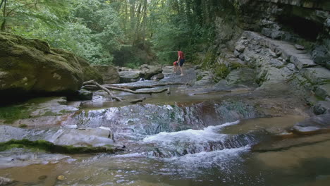 forest creek with waterfall and people