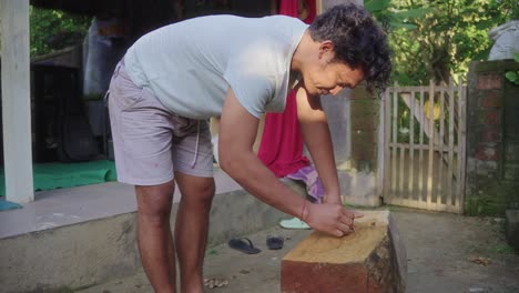 indonesian artisan drawing on wood to create a sculpture slow motion