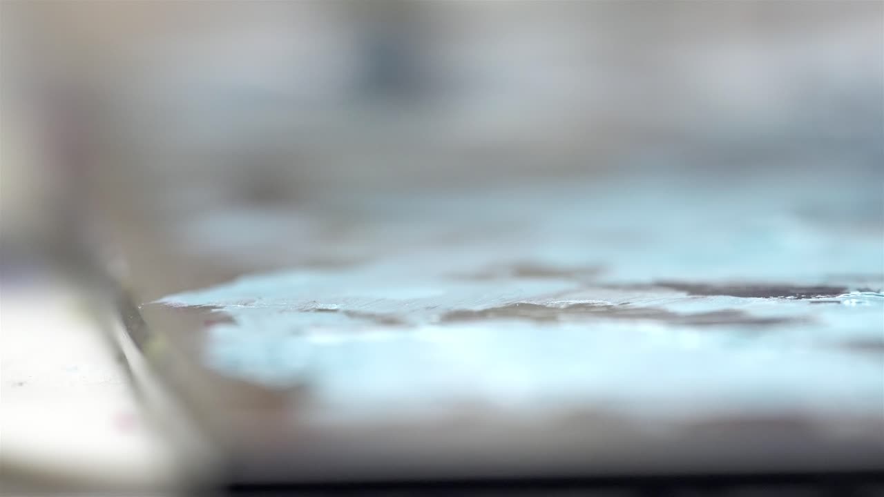 Macrofotografia di pittura blu bagnata mescolata su tavolozza d'artista