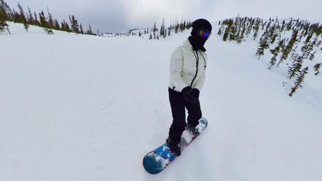 persona haciendo snowboard durante el invierno por una montaña