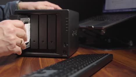 persona que inserta un disco duro en un servidor de computadora