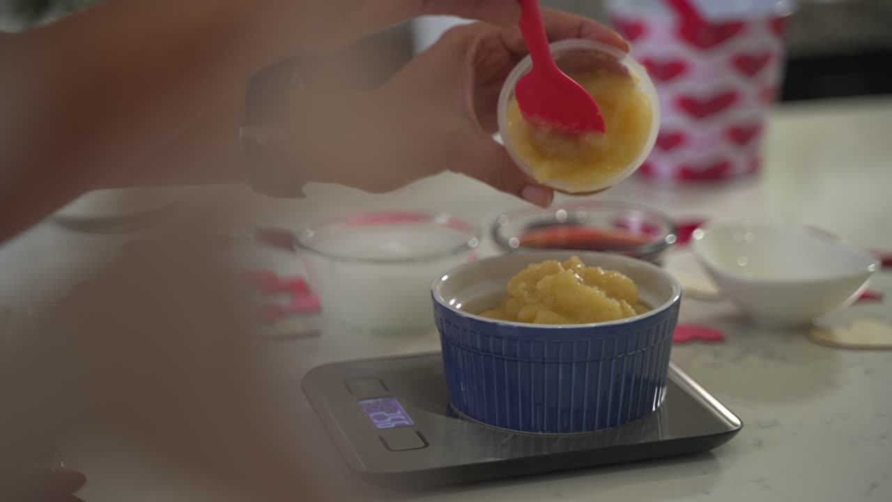 añadiendo salsa de manzana en un cuenco haciendo un pastel especial del día de san valentín pastel de chocolate vegano sin huevos a base de plantas sin lácteos