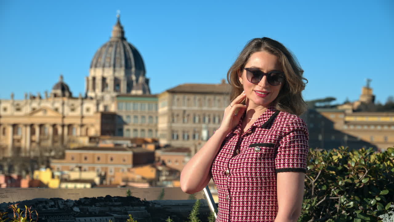 Blonde young woman in sunglasses smiles with Vatican city in background. Saint Peter's Basilica at sunset. Rome, Italy