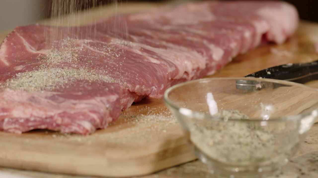 agarrar con la mano las especias, frotar desde el cuenco hasta sazonar las costillas de cerdo a la parrilla antes de cocinar