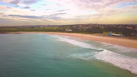 aerial shot of surfers catching waves, surfing in winter on a windy cloudy morning, maroubra beach, sydney australia