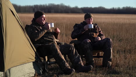 men camping and drinking outdoors
