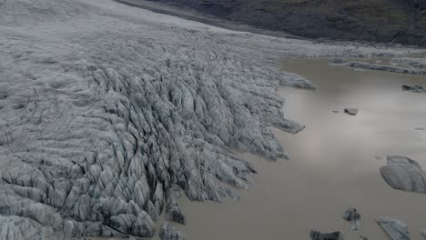 Vista-De-Arriba-Hacia-Abajo-De-La-Laguna-De-Hielo-Derretido-Del-Glaciar-Skaftafell,-Crisis-Climática,-Incline-Lentamente-Hacia-Arriba