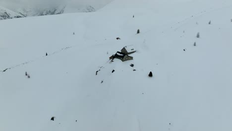 small mountain hut covered in snow in the austrian alps