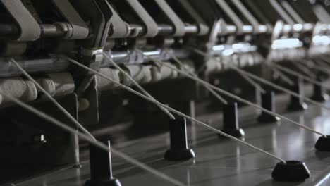 Close-up-shot-of-yarn-being-fed-through-pulleys-into-the-Ringframe